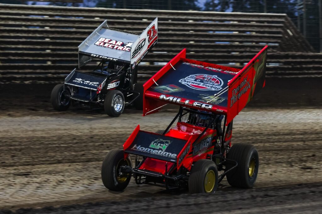Two Sprint Cars racing side-by-side around Knoxville Raceway