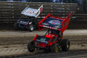 Two Sprint Cars racing side-by-side around Knoxville Raceway