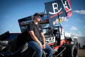 Cole Schroeder sits on the front left tire of his Sprint Car